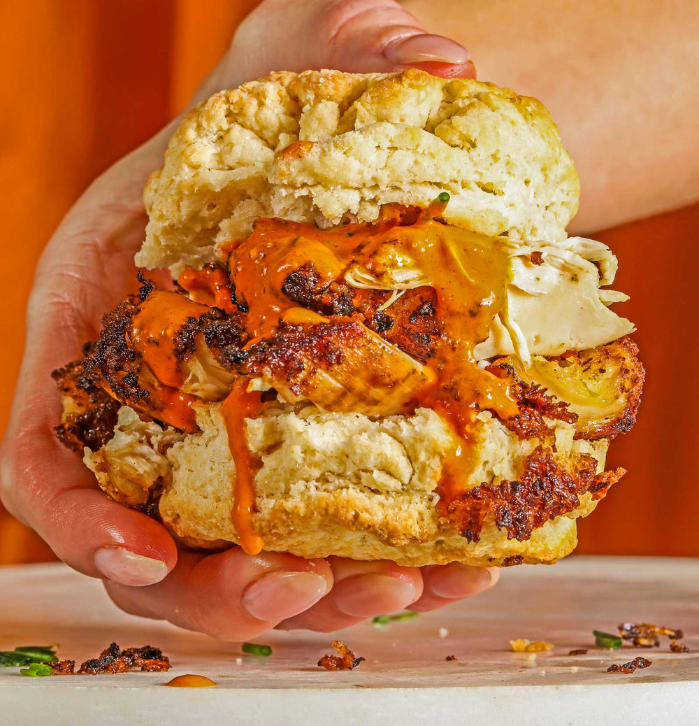 Yellowbird Serrano Coconut Hot Sauce on a grilled chicken sandwich