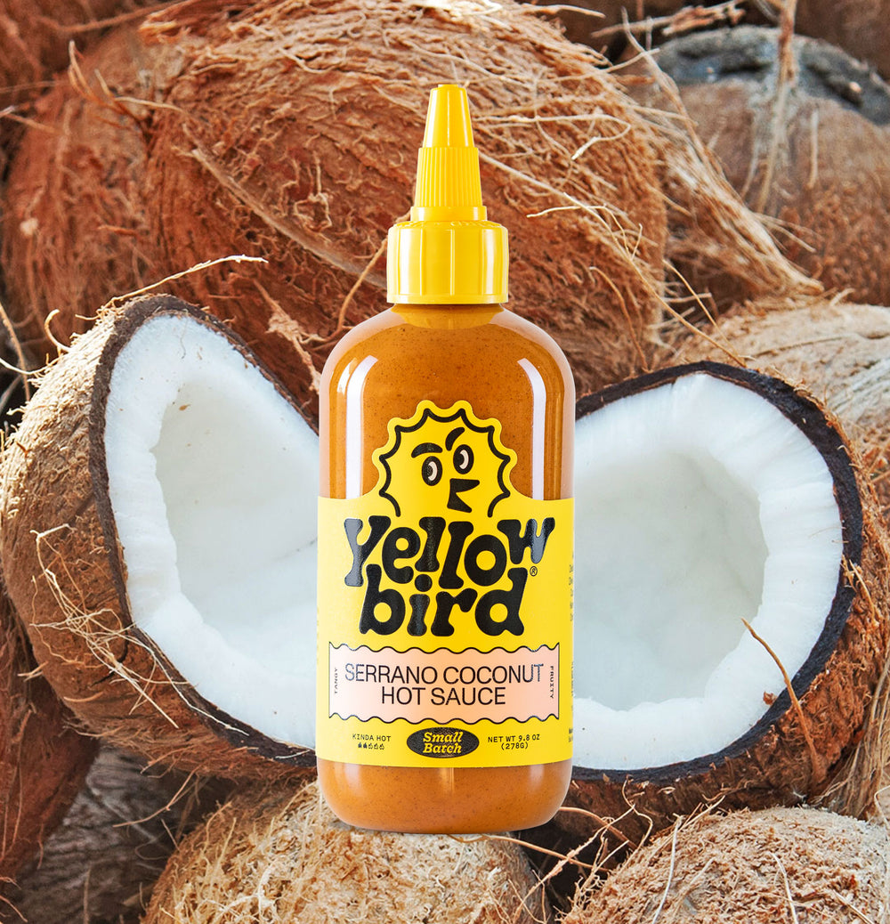 Yellowbird Serrano Coconut Hot Sauce 9.8 oz. with ingredients in background